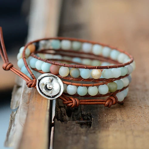 Bracelet Boho (wrap) en Amazonite trois tours posé à cheval sur un rebord en bois et un parquest en bois vue de face Kaosix