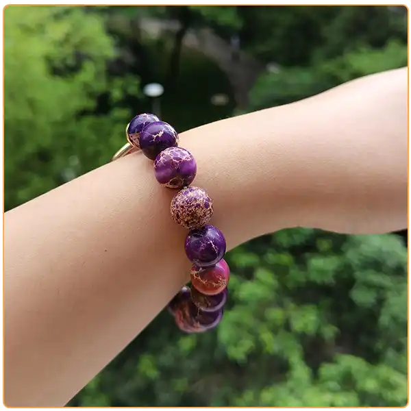 Bracelet Jaspe Impérial Cœur repose au poignet d'une femme vue de profil kaosix