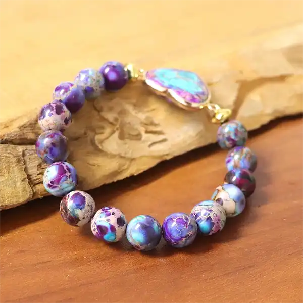 Bracelet Jaspe Impérial Cœur repose sur un morceau de bois vue de profil kaosix