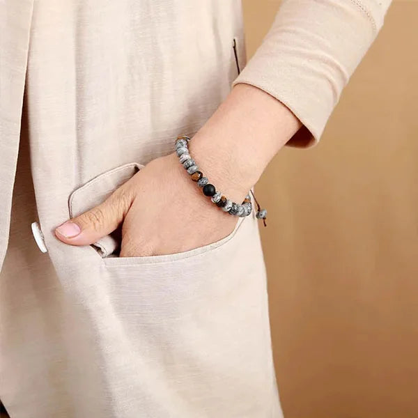 Bracelet Tibétain Jaspe Gris et Œil de Tigre au poignet d'une femme main dans la poche de sa blouse beige kaosix