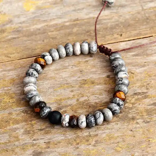 Bracelet Tibétain Jaspe Gris et Œil de Tigre posé sur du bois vue de dessus kaosix