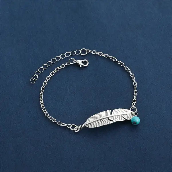 Bracelet de Cheville Plume Argentée et Perle Turquoise sur tapis bleu kaosix