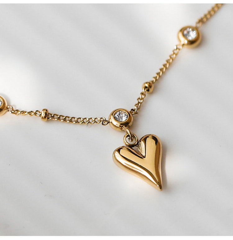 Bracelet de cheville en acier inoxydable doré pendentif cœur et zircons cubiques avec gros plan sur le pendentif coeur Kaosix