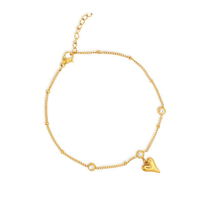 Bracelet de cheville en acier inoxydable doré pendentif cœur et zircons cubiques sur fond blanc Kaosix