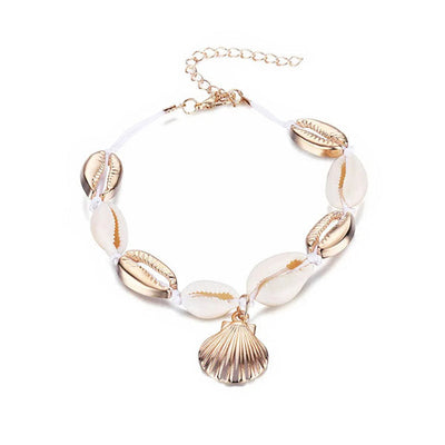 Bracelet de cheville en coquillages cauris avec amulette coquille Saint-Jacques couleur or sur fond blanc Kaosix