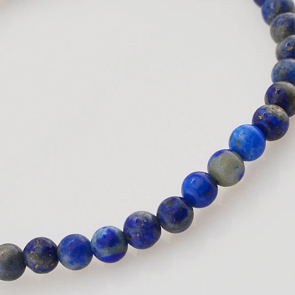Bracelet en Lapis Lazuli Harmonie (boule 4 mm) sur fond gris en gros plan sur les perles kaosix