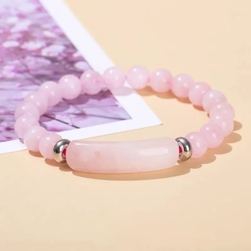 Bracelet en Quartz Rose Bande Courbe et Perles à cheval sur une image et sur une nappe beige kaosix