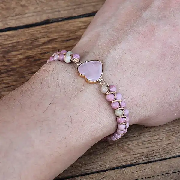 Bracelet en Rhodonite et Cœur Quartz Rose au poignet d'une femme kaosix