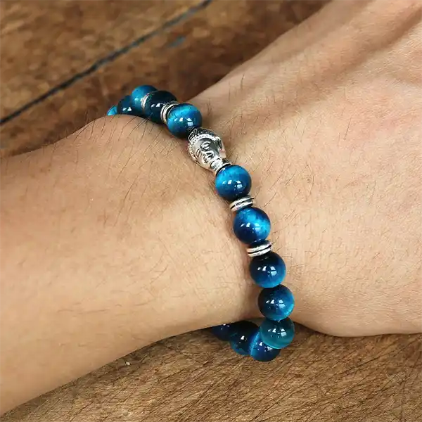 Bracelet œil de tigre bleu tête de Bouddha au poignet d'un homme Kaosix
