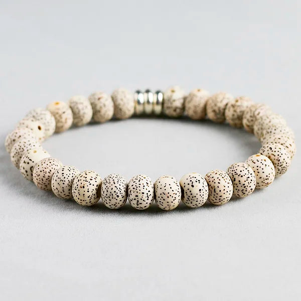Bracelet tibétain graine de bodhi protection posé sur un sol gris Kaosix