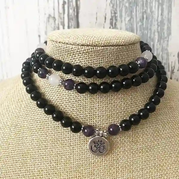 Mala 108 perles Onyx Noir Améthyste Om posé autour d'un cou de buste de mannequin kaosix