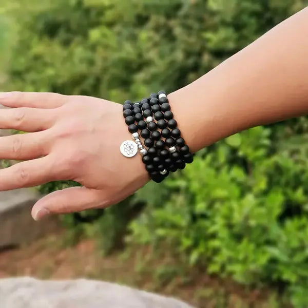 Mala 108 perles Onyx Noir Bouddha au poignet d'un jeune homme kaosix