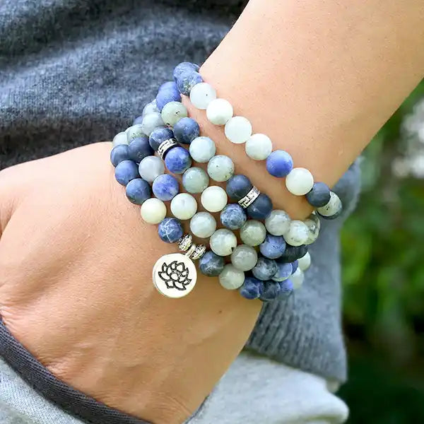 Mala 108 perles Pierre de Lune Sodalite Lotus enroulé autour du poignet d'une jeune femme kaosix