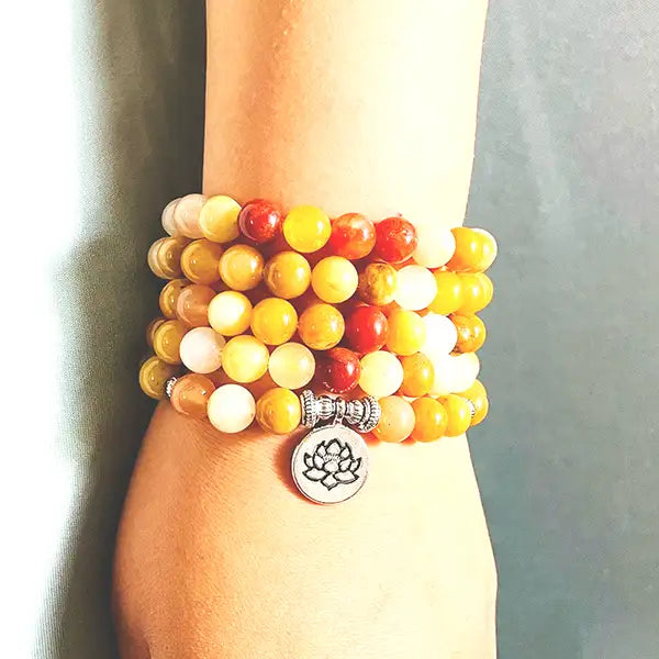 Mala 108 perles en Aventurine Jaune Lotus au poignet d'une femme kaosix