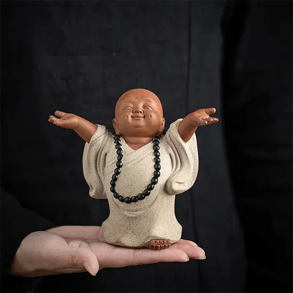 Statues Moines Bouddhistes Bienveillants Le Moine de la Joie sur la paume d'une main d'homme Kaosix