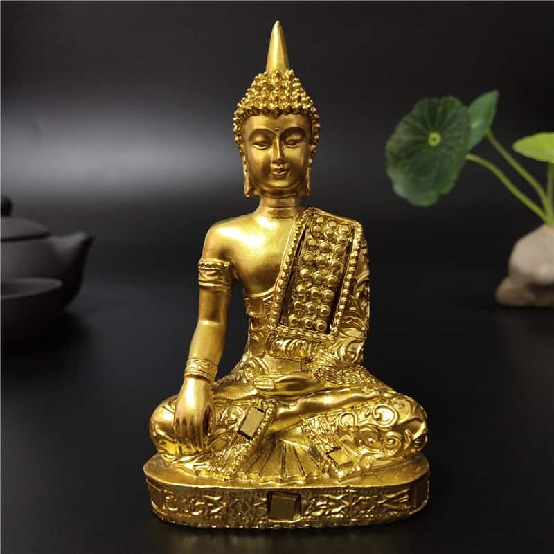 Statuette Bouddha Thaïlande Dorée Appel à la Terre posée sur table noire et fond noir Kaosix