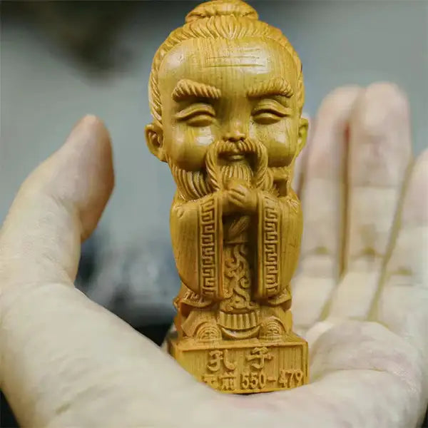 Statuette Confucius en Bois de Cyprès Personnage Chinois Emblématique posée sur une main d'homme kaosix