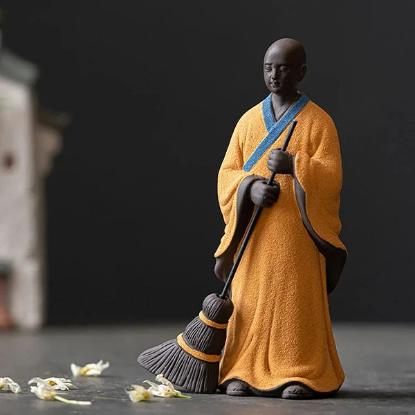Statuette moine bouddhiste avec un balai couleur orange fleurs kaosix