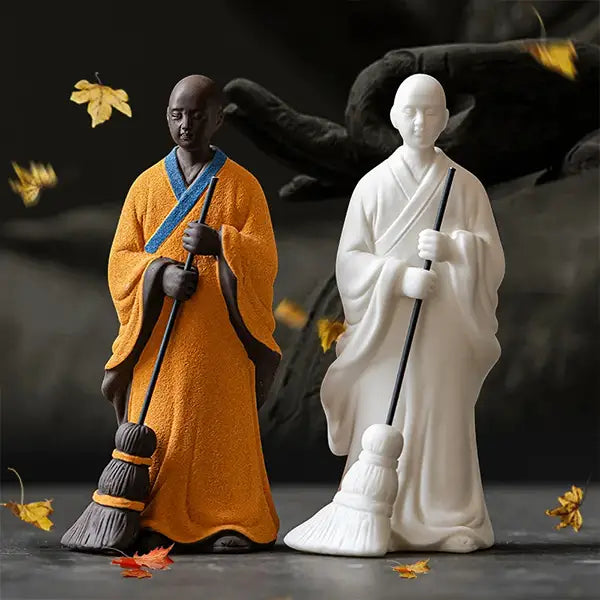 Statuette moine bouddhiste avec un balai couleurs blanc et orange feuilles kaosix