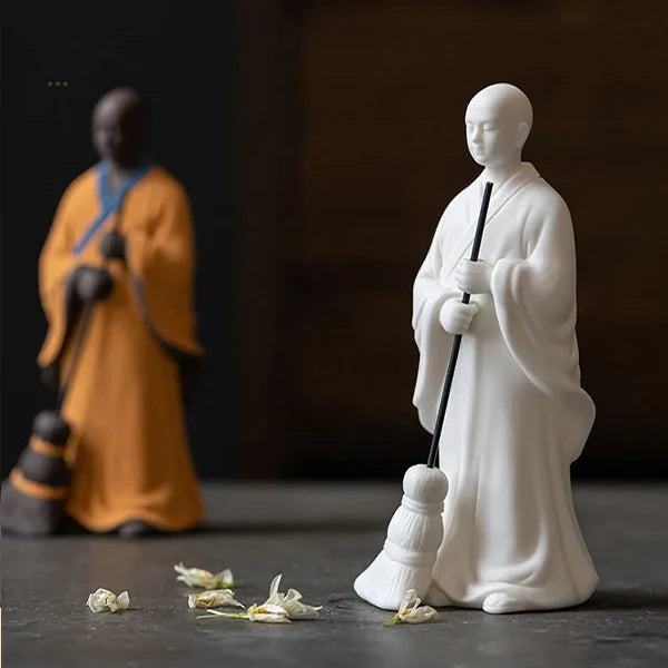 Statuette moine bouddhiste avec un balai couleurs blanc et orange flou kaosix