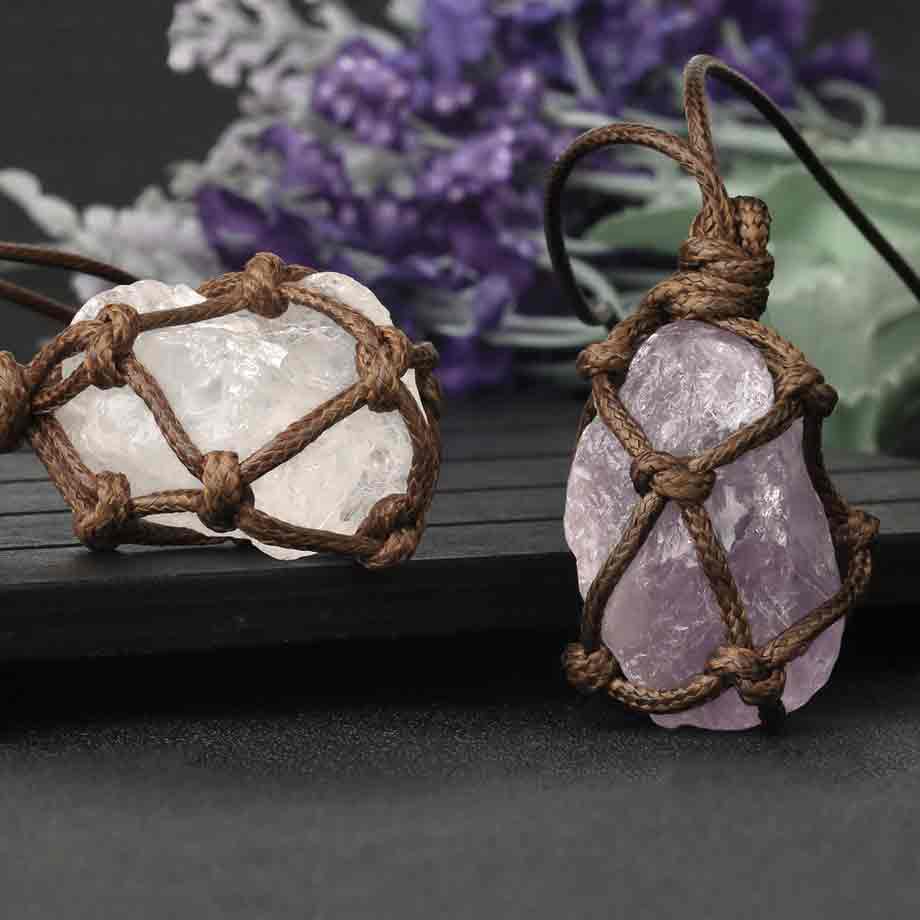 2 pendentif pierre brute cordon wrap améthyste et cristal de roche sur un tapis gris foncé Kaosix