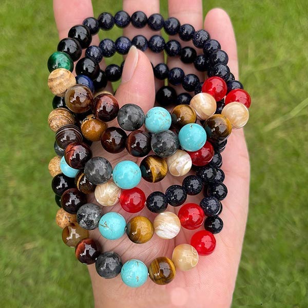 5 Bracelets Système Solaire avec 11 Planètes en Perles de Pierres posés sur une peaume de main de femme Kaosix