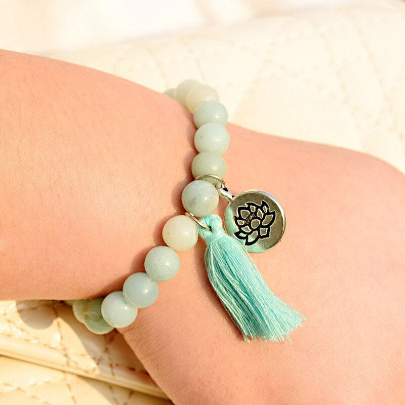 Bracelet amazonite verte symbole lotus sur le poignet d'une jeune fille Kaosix