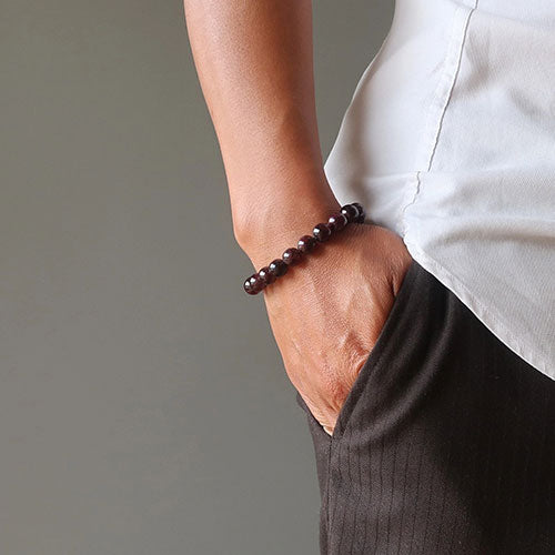 Bracelet en grenat amour sur le poignet d'une jeune femme vue gros plan Kaosix