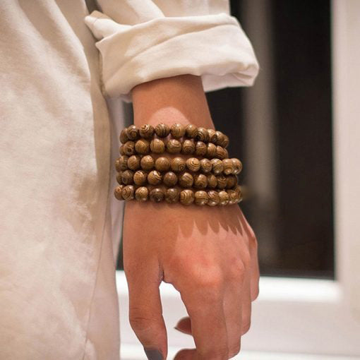 Mala 108 perles bois de santal avec pompon enroulé autour d'un poignet d'homme Kaosix