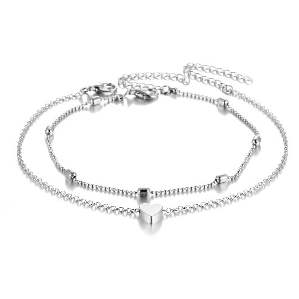 Set de deux bracelets de cheville avec amulette cœur couleur argenté sur fond blanc Kaosix