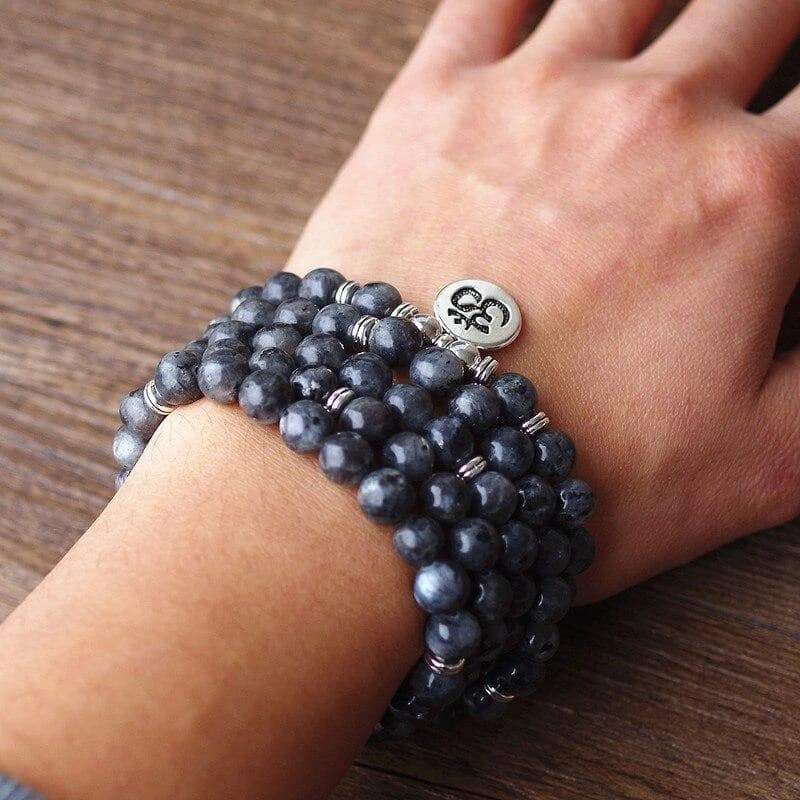 bracelet mala 108 perles labradorite OM enroulé autour du poignet de jeune femme