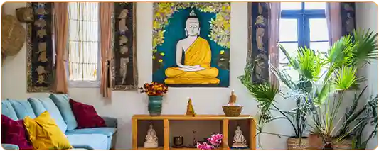 Un salon familial avec un tableau de Bouddha sur le mur encadré par deux fenêtres Kaosix