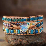 Bracelet Boho (wrap) Cœur d’opale Bleue posé sur une pierre ronde et vue de face Kaosix