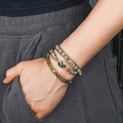 Bracelet Boho (wrap) Labradorite Équilibre au poignet d'une femme en pantalon de velours gris kaosix