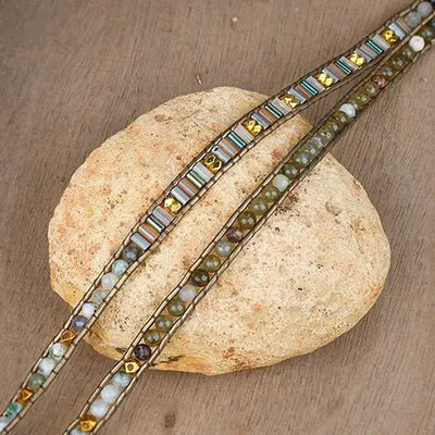 Bracelet Boho (wrap) Labradorite Équilibre déroulé et posé sur une pierre blanche sur un sol en bois kaosix