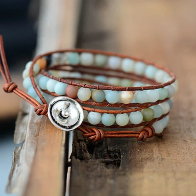 Bracelet Boho (wrap) en Amazonite trois tours posé à cheval sur un rebord en bois et un parquest en bois vue de face Kaosix