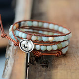 Bracelet Boho (wrap) en Amazonite trois tours posé à cheval sur un rebord en bois et un parquest en bois vue de face Kaosix