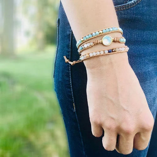 Bracelet Boho (wrap) en Opale Bleue Ronde au poignet d'une jeune femme vêtue d'un jeans Kaosix