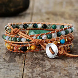 Bracelet Boho (wrap) en pierre de Jade Vert Turquoise Onyx Lave sur un plancher en bois vue de derrière Kaosix