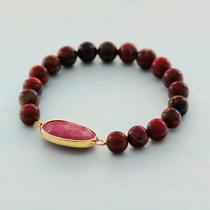 Bracelet Jaspe Rouge et Rhodonite posé sur une surface grise kaosix