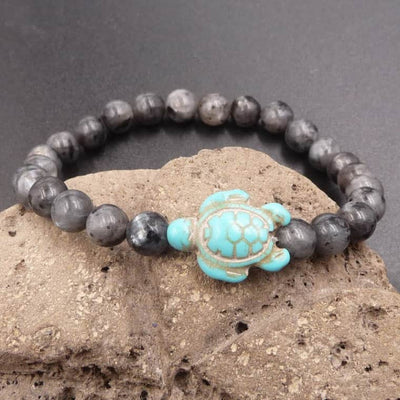 Bracelet Labradorite Grise Tortue Marine sur un rocher gris Kaosix