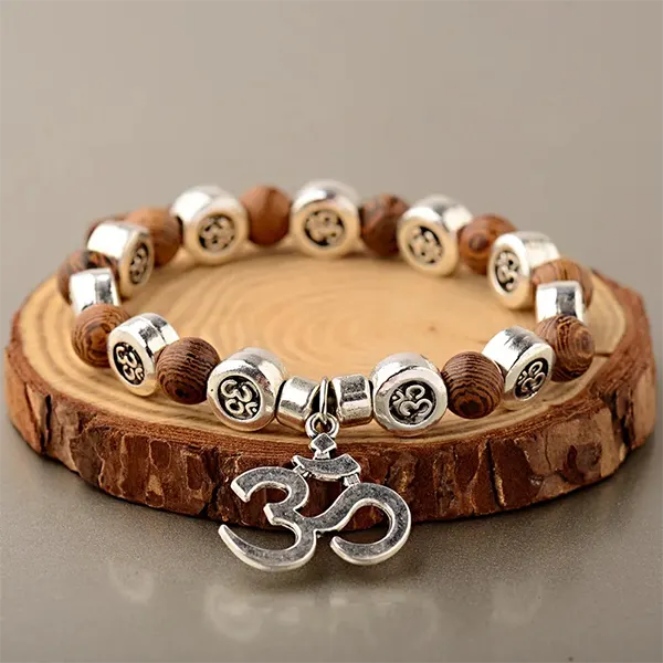 Bracelet OM Bois et Métal posé sur une rondelle de bois kaosix