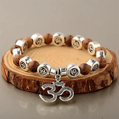 Bracelet OM Bois et Métal posé sur une rondelle de bois kaosix