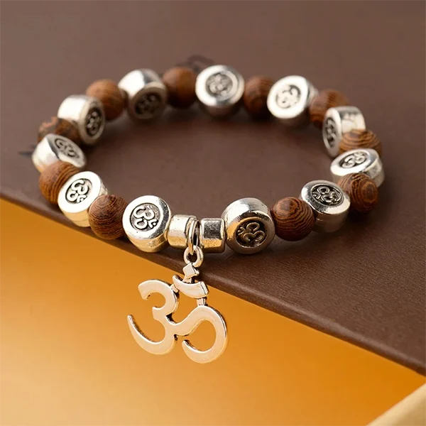 Bracelet OM Bois et Métal sur une surface jaune et marron kaosix