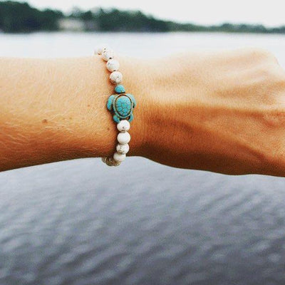 Bracelet Pierre de soleil Tortue Marine au poignet d'une femme Kaosix