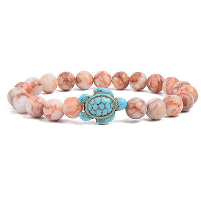 Bracelet Pierre de soleil Tortue Marine sur un sol blanc Kaosix