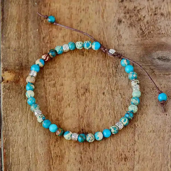 Bracelet Tibétain Bleu Turquoise sur un plancher en bois vue de dessus kaosix