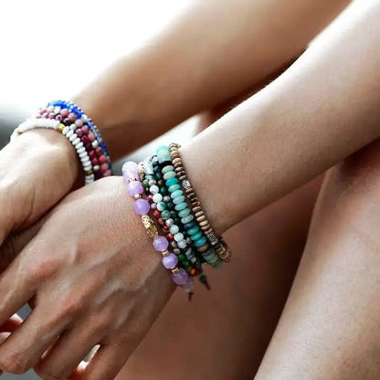 Bracelet Tibétain en Jaspe Paysage et Anneaux Métalliques Gravés autour d'un poignet de femme avec d'autres bracelets kaosix