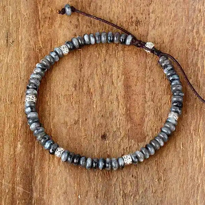 Bracelet Tibétain en Labradorite et Anneaux Métalliques Gravés sur un plancher en bois vue de dessus kaosix