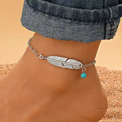 Bracelet de Cheville Plume Argentée et Perle Turquoise à la cheville d'une femme Kaosix